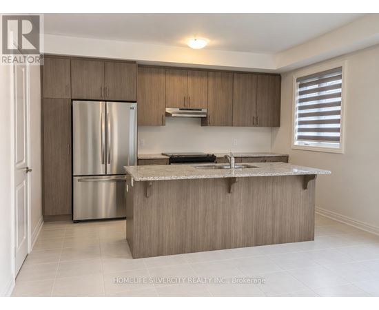 A kitchen with a refrigerator, sink, and cabinets.
