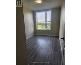 A room with a window and wooden flooring.