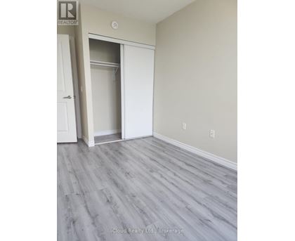 A room with a white door and a grey floor.