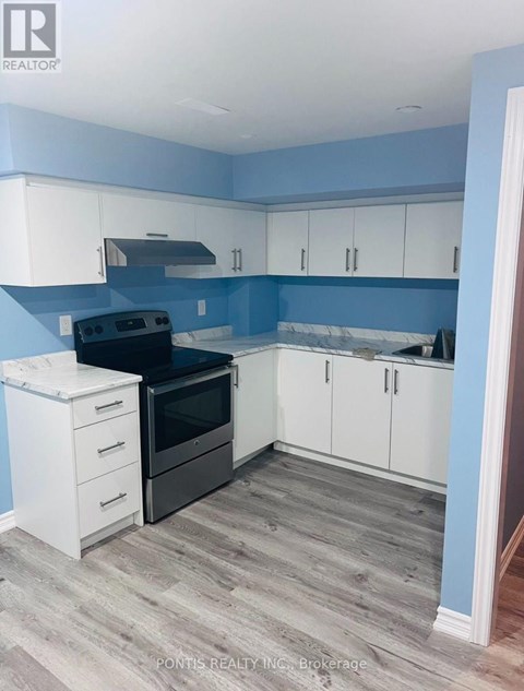 A kitchen with a black oven and white cabinets.