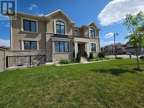 A large, modern house with a well-kept lawn in front.