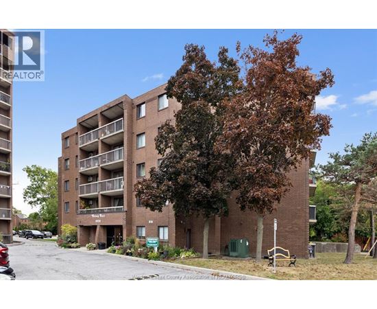 Apartment building with a tree in front of it.