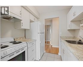 A kitchen with white appliances and cabinets.