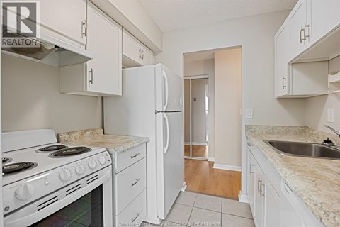 A kitchen with white appliances and cabinets.