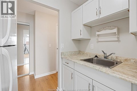 A kitchen with white cabinets and a marble countertop.