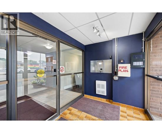The image shows a glass door entrance to a building with a sign that reads "FIRE PLAN.".