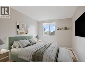 A bedroom with a bed, nightstand, and lamp.
