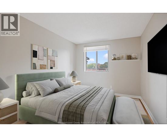 A bedroom with a bed, nightstand, and lamp.