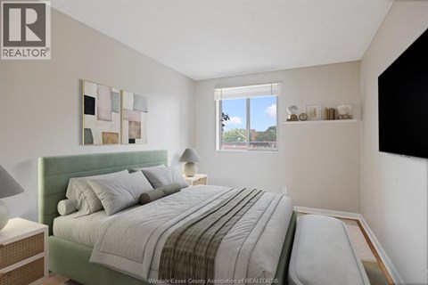 A bedroom with a bed, nightstand, and lamp.