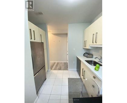 A kitchen with white cabinets and a white fridge.