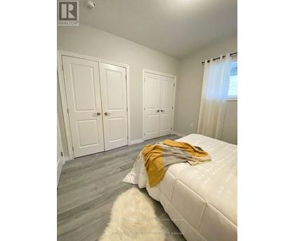 A bedroom with a white bed and two white doors.