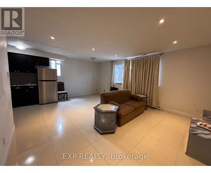 A spacious living room with a couch, a table, and a television.