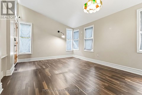 A room with wooden floors and a light fixture on the wall.