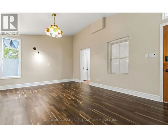 A room with wooden floors and a chandelier hanging from the ceiling.
