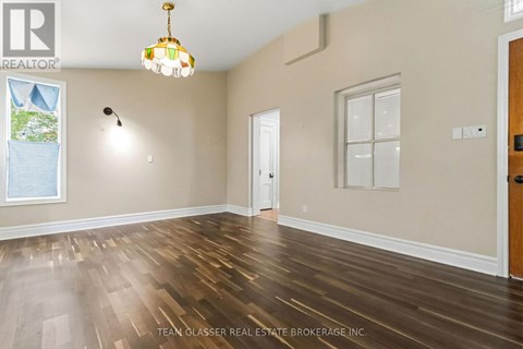A room with wooden floors and a chandelier hanging from the ceiling.