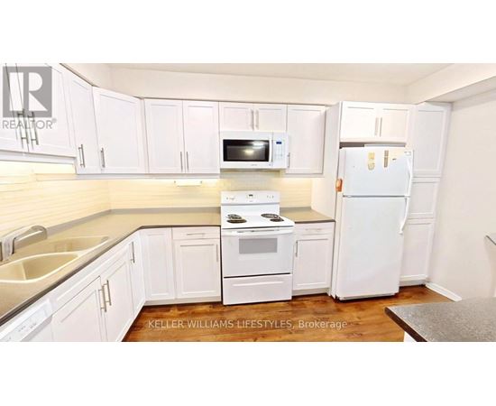 A kitchen with white appliances and cabinets.