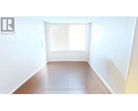 A room with a window and wooden floor.