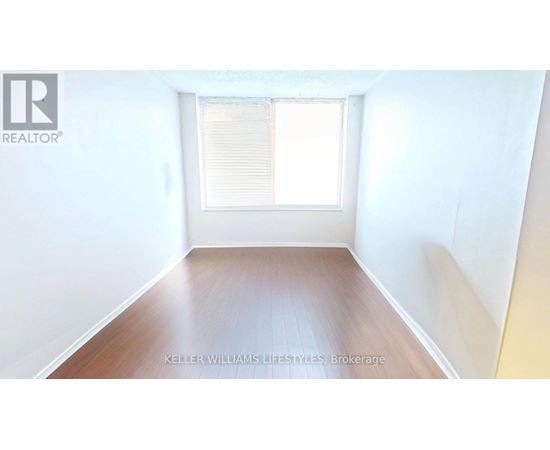 A room with a window and wooden floor.