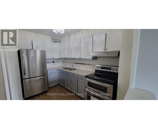 A kitchen with white cabinets and a stainless steel refrigerator.