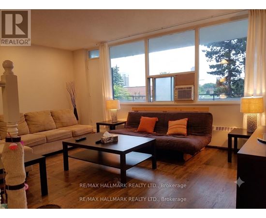A living room with a brown couch, a coffee table, and a lamp.