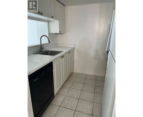 A kitchen with white cabinets and a black dishwasher.