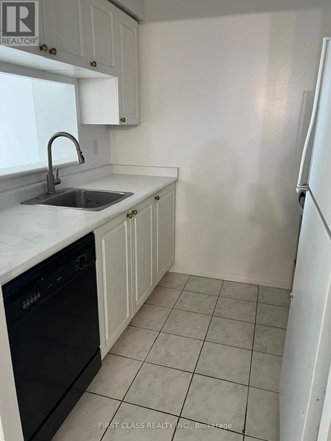 A kitchen with white cabinets and a black dishwasher.