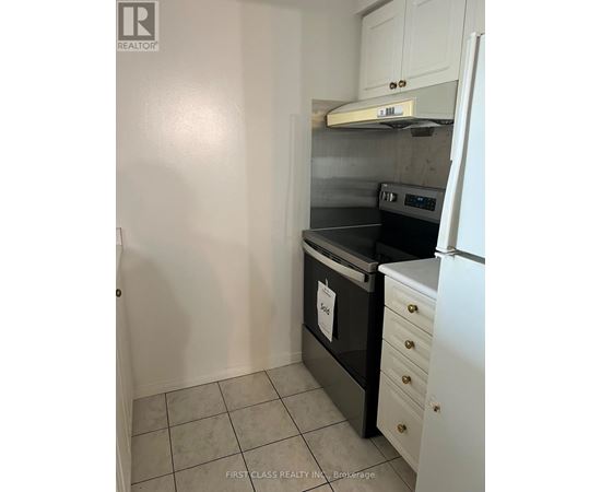 A kitchen with a black oven and white cabinets.
