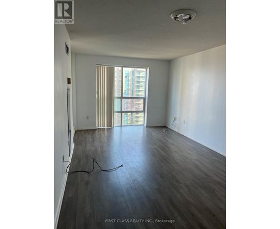 A room with wooden flooring and a window with blinds.
