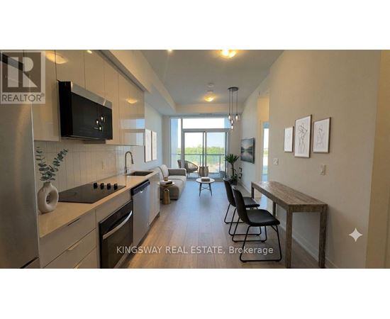 A kitchen with a stainless steel refrigerator and a television mounted above the stove.