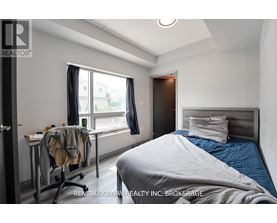 A bedroom with a bed, desk, and chair.