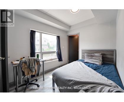 A bedroom with a bed, desk, and chair.