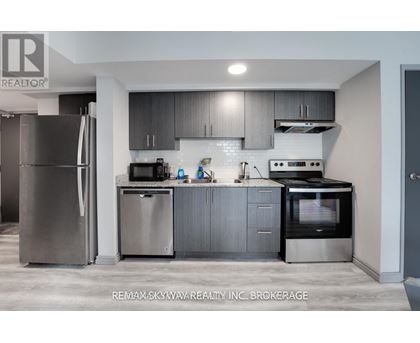 A modern kitchen with stainless steel appliances and grey cabinets.