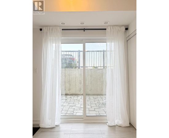 A white curtain is hanging on a sliding glass door.