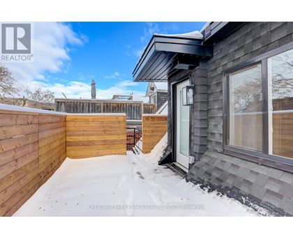 A house with a grey roof and a wooden fence is shown in the image.
