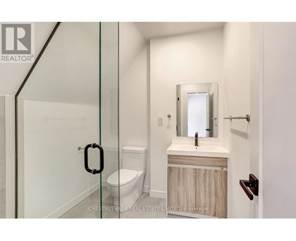 A bathroom with a toilet, sink and mirror.