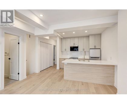 A modern kitchen with white cabinets and a wooden island.