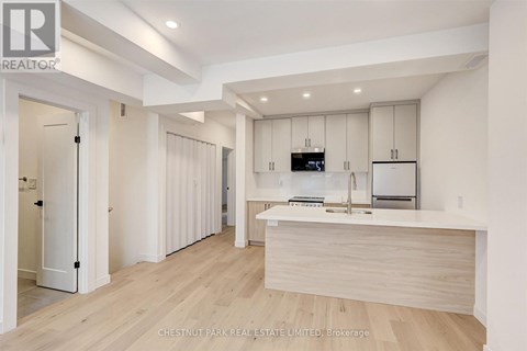 A modern kitchen with white cabinets and a wooden island.