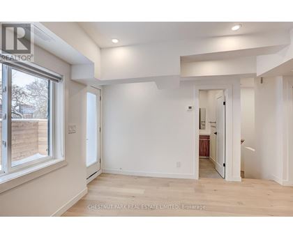 A spacious room with white walls and a large window.