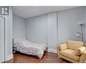 A bedroom with a bed and a chair.