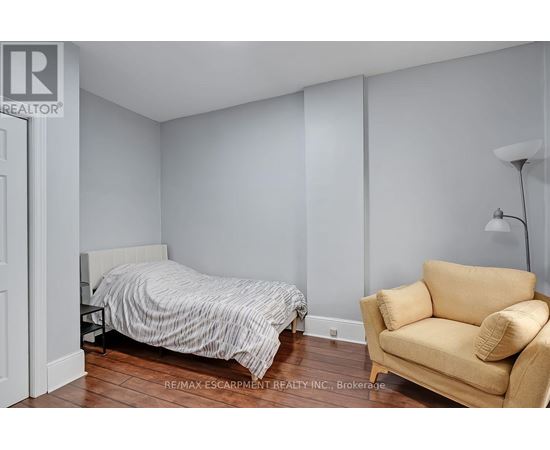 A bedroom with a bed and a chair.