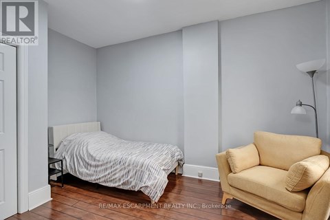 A bedroom with a bed and a chair.