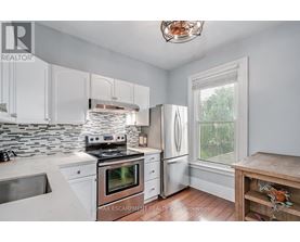 A kitchen with white cabinets and a stove top oven.