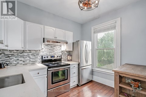A kitchen with white cabinets and a stove top oven.