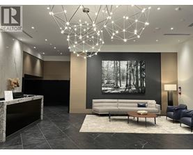 A modern living room with a grey sofa, a coffee table, and a large chandelier.