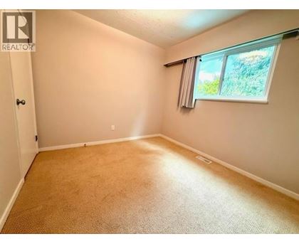 A room with a window and carpeted floor.