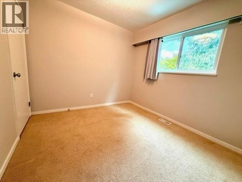 A room with a window and carpeted floor.