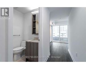A bathroom with a toilet, sink, and a window.