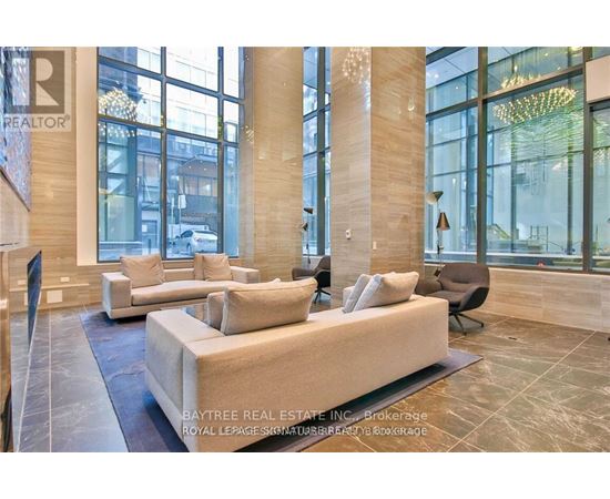 A living room with a large couch and a chandelier.