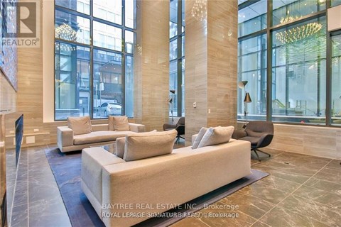 A living room with a large couch and a chandelier.