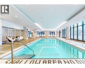 A large indoor swimming pool with a sign that says "SALON AREA NO DIPPING".